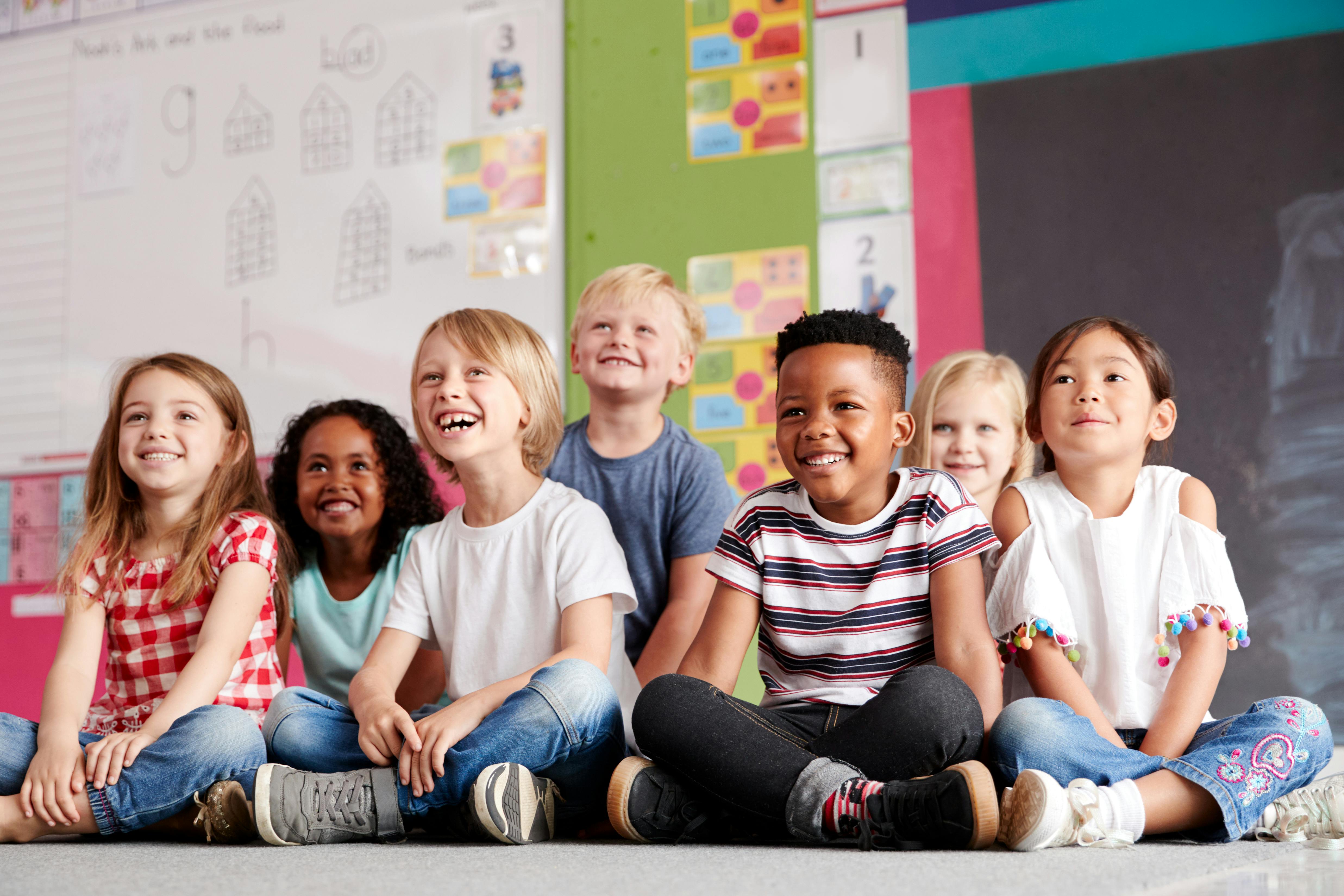 Group of children sitting on the floor in a classroom