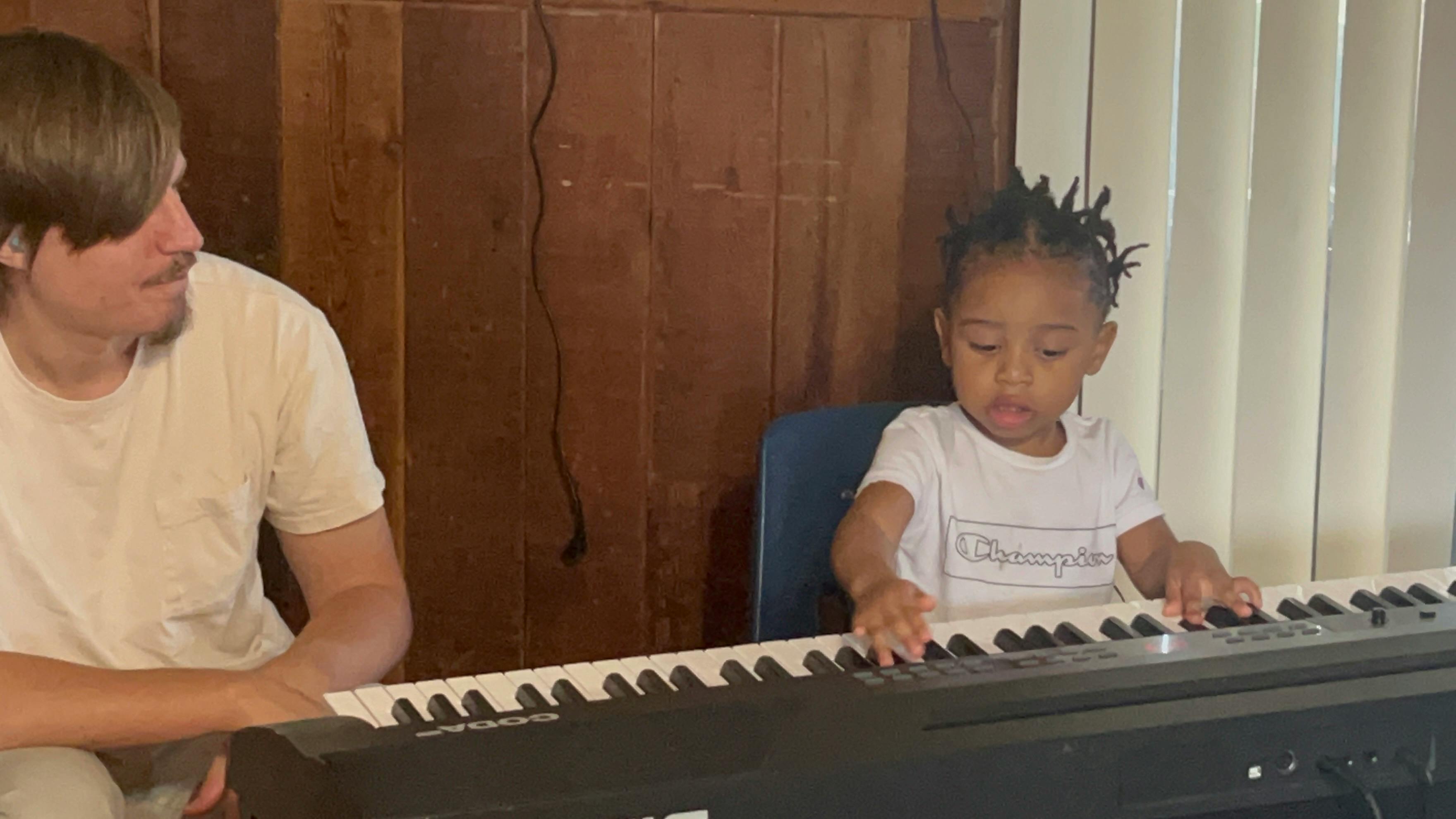 Person and child playing a keyboard
