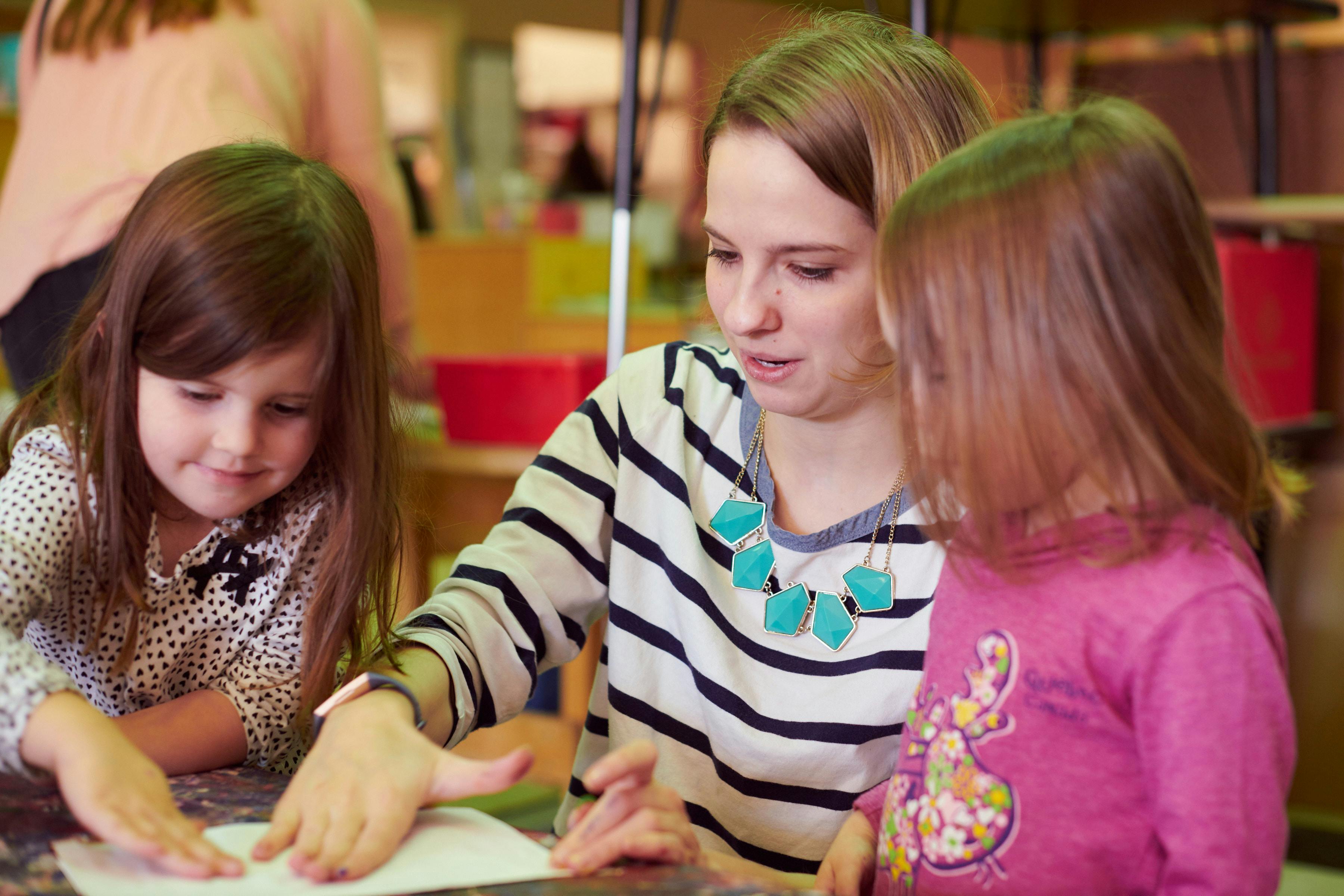 Adult and two children looking at paper