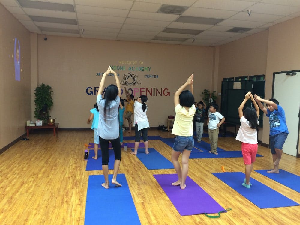 People doing yoga in a studio with arms raised