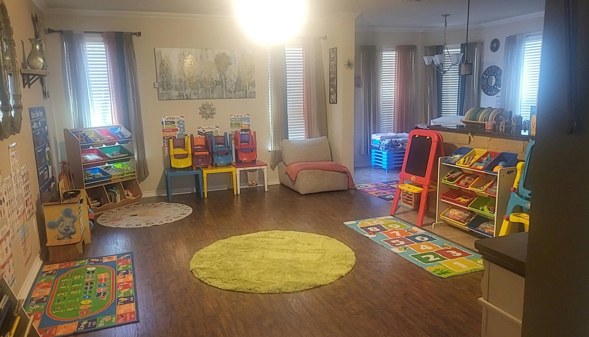 Playroom with colorful rugs, small chairs, and toy storage
