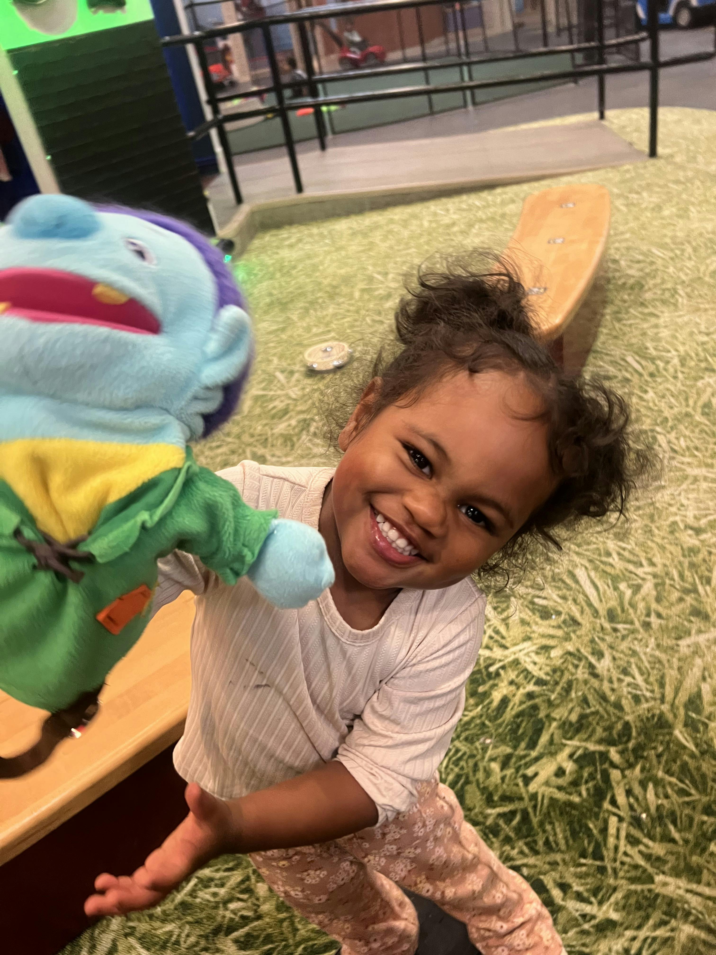 Child holding a blue puppet