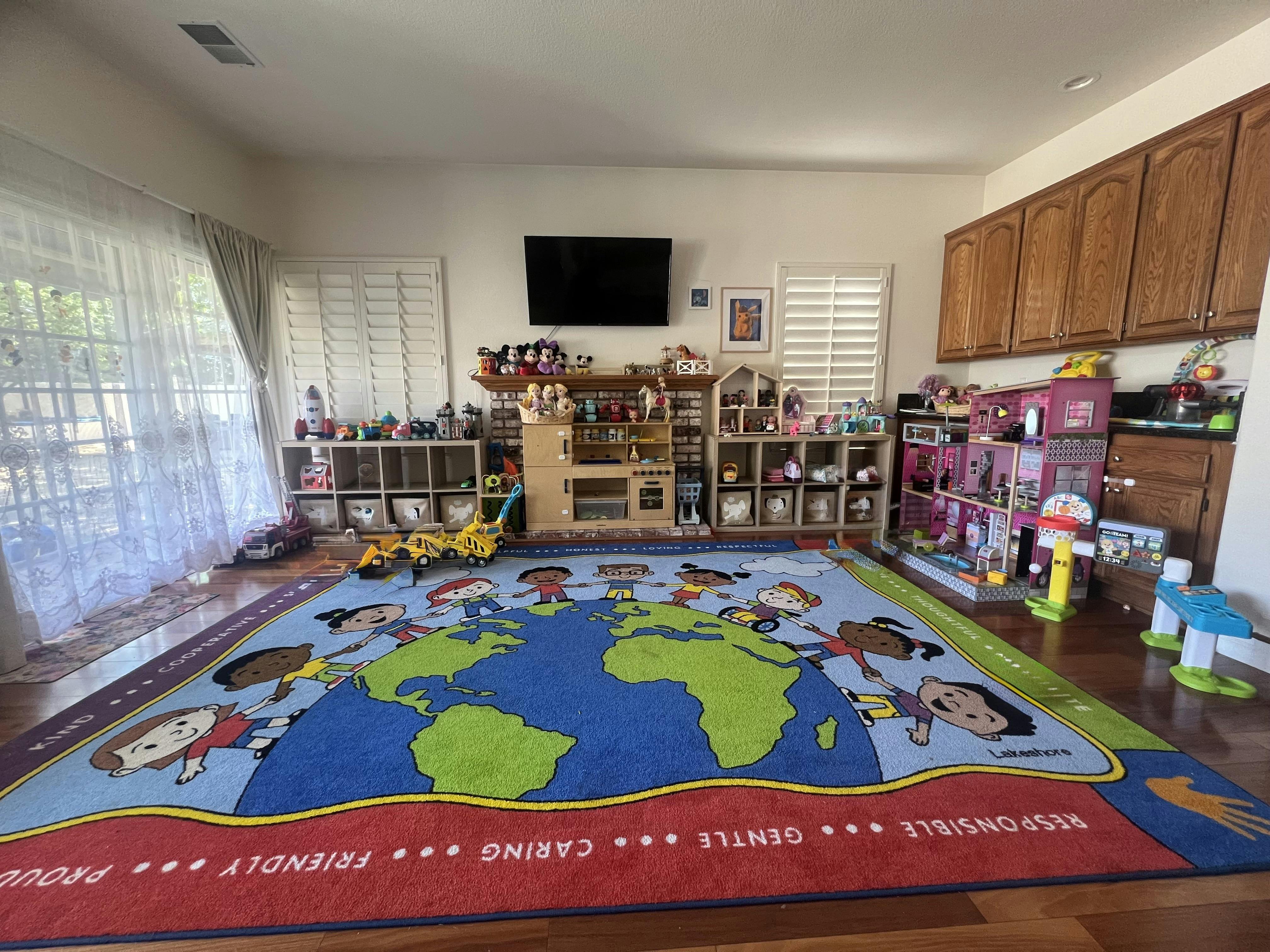 A children's playroom with a large rug depicting children holding hands around the world