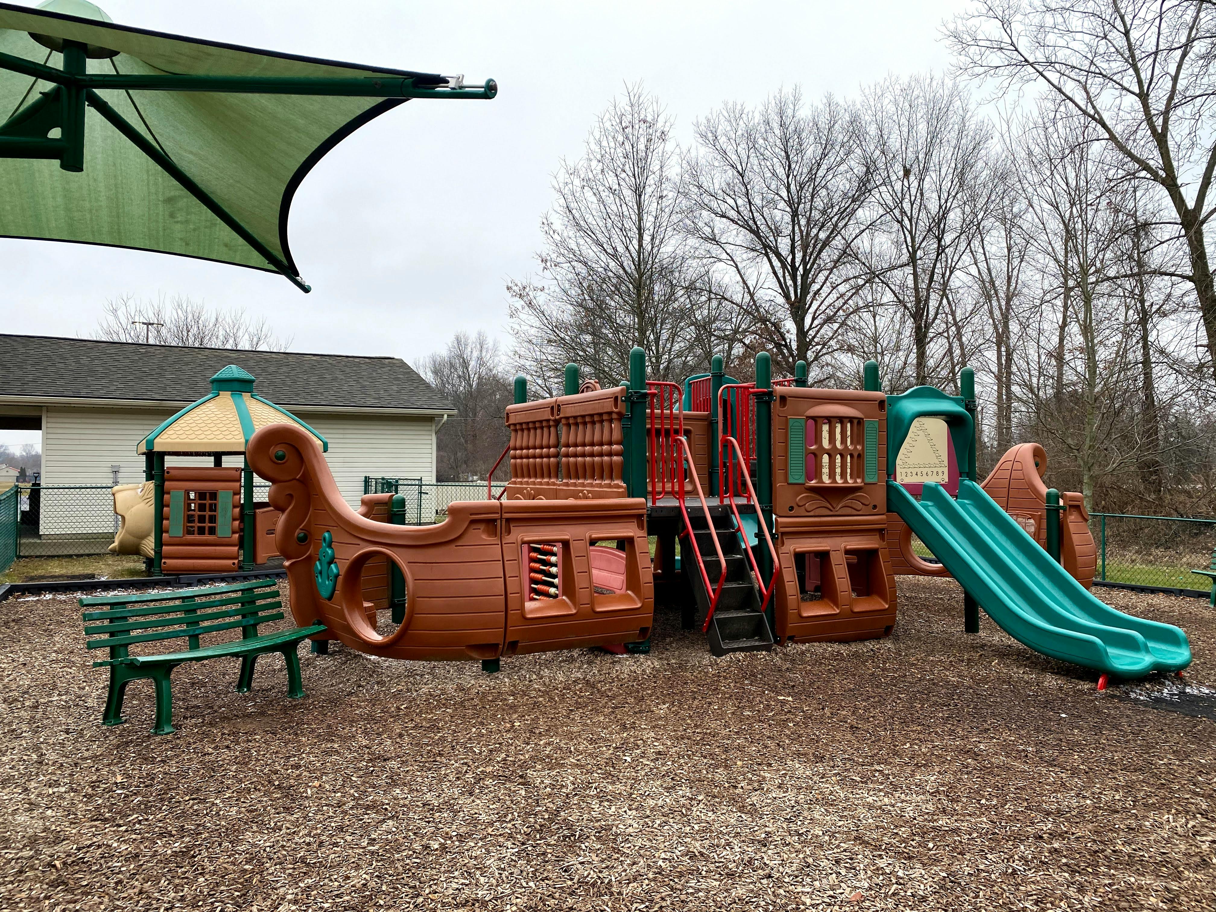 Playground with a ship-shaped structure and green slides