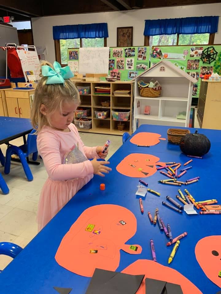 Child making crafts at a blue table