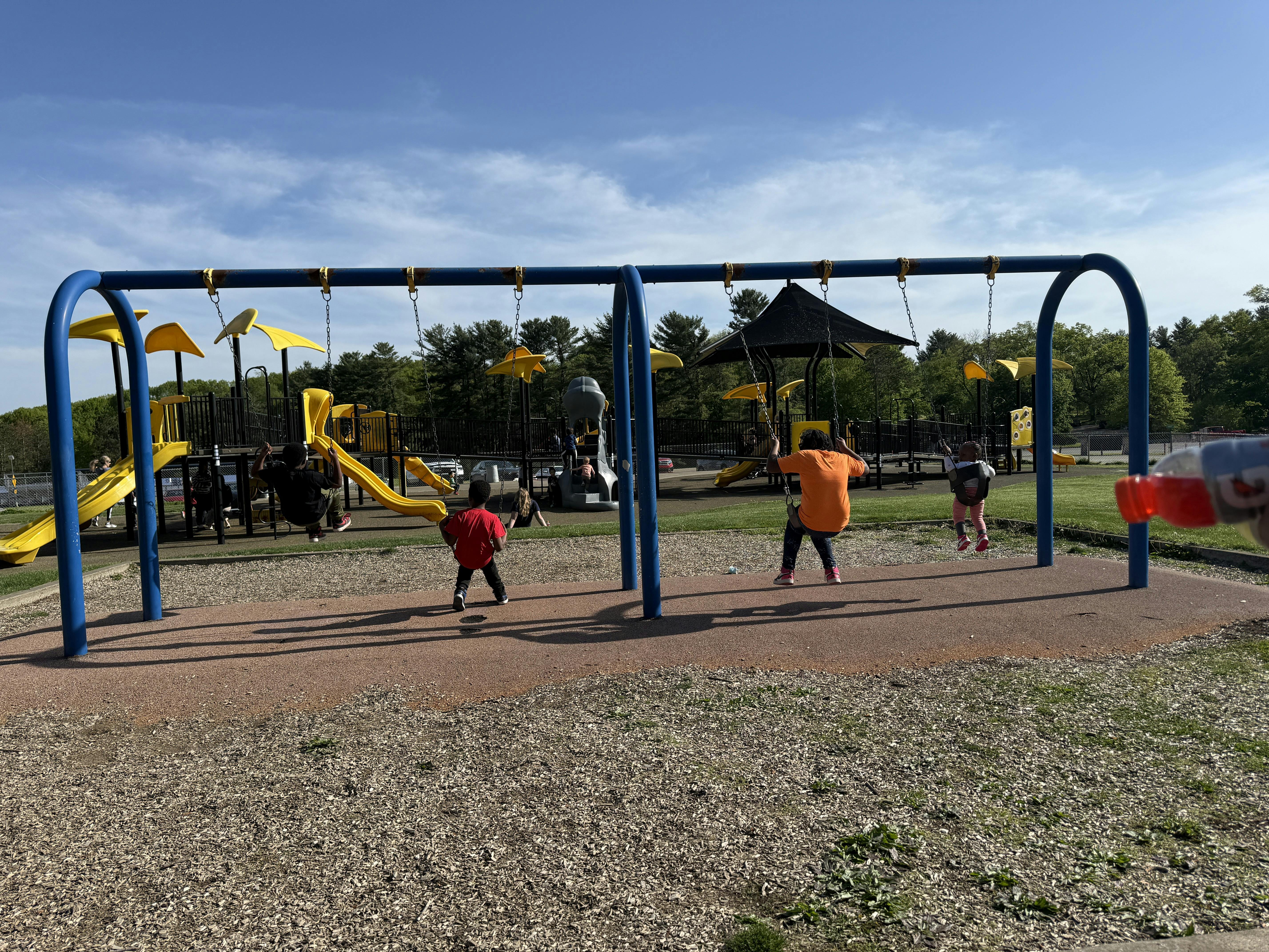 Children playing on swings and playground equipment