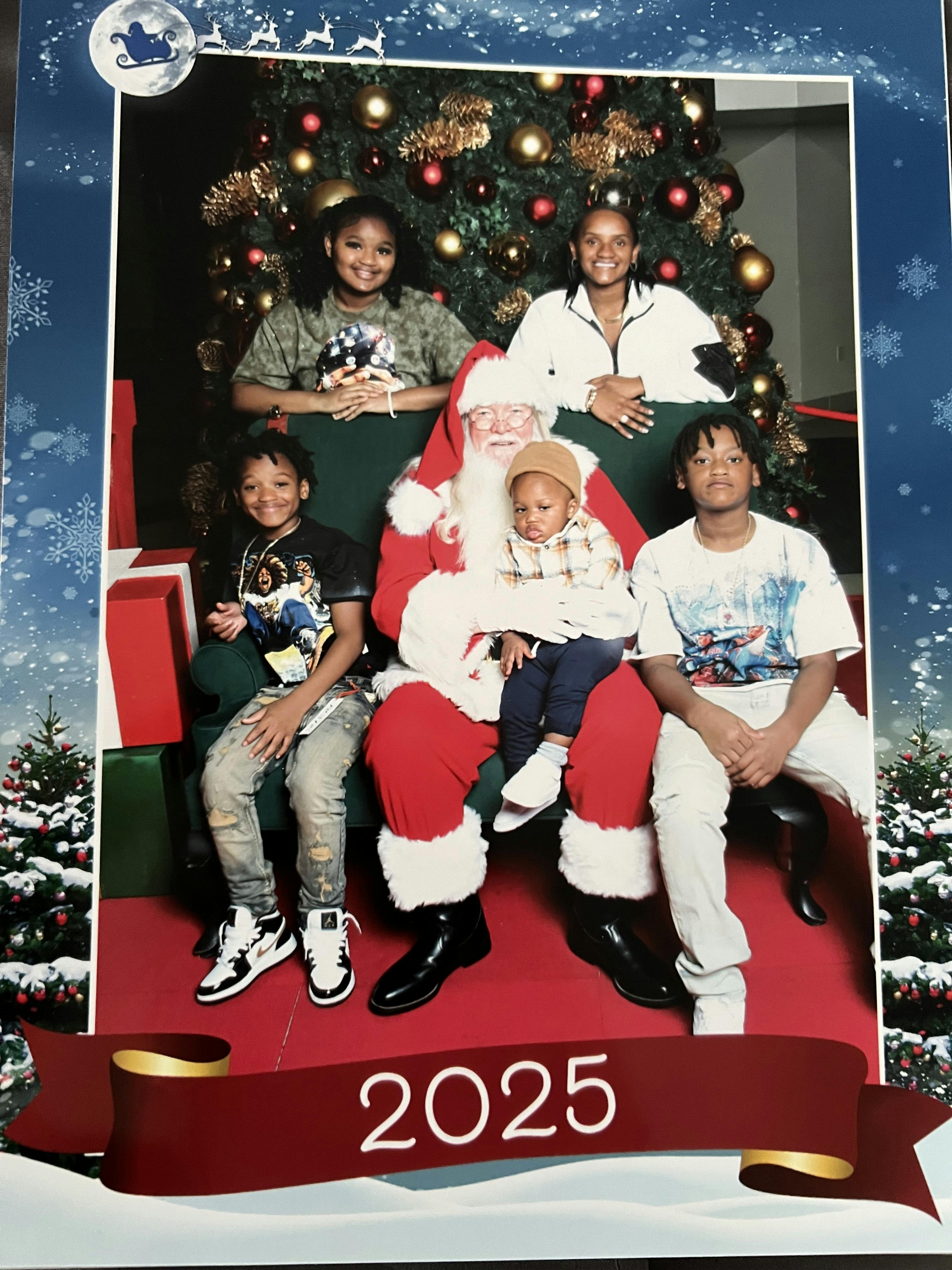 Santa Claus with a child on his lap and four other people around him