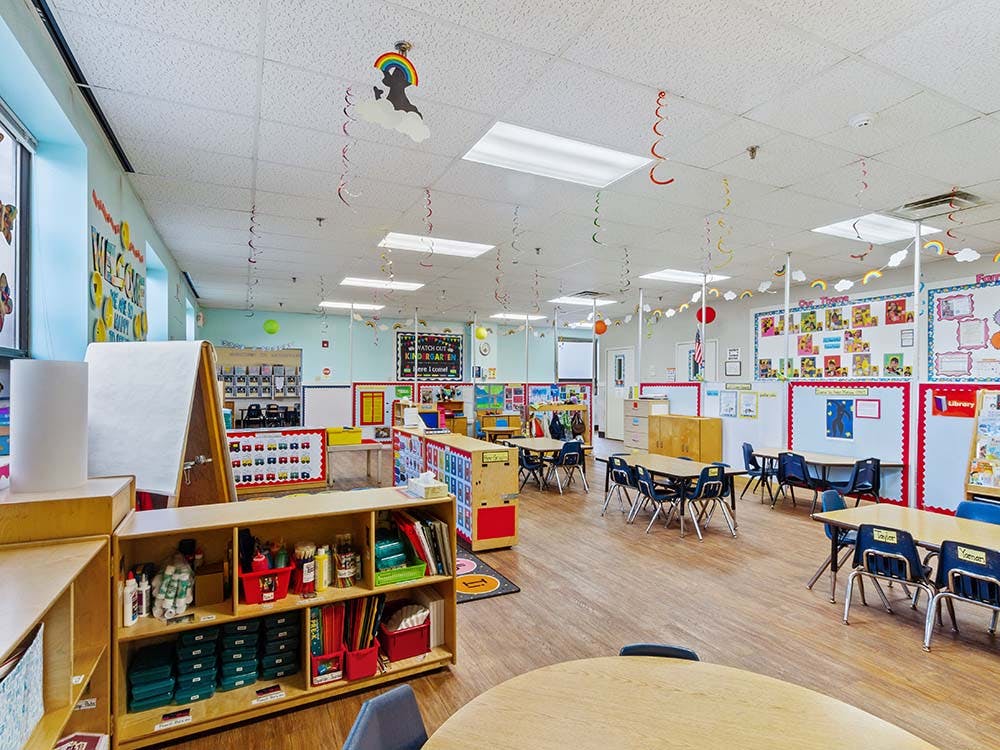 Classroom with small tables and chairs, decorated with colorful elements