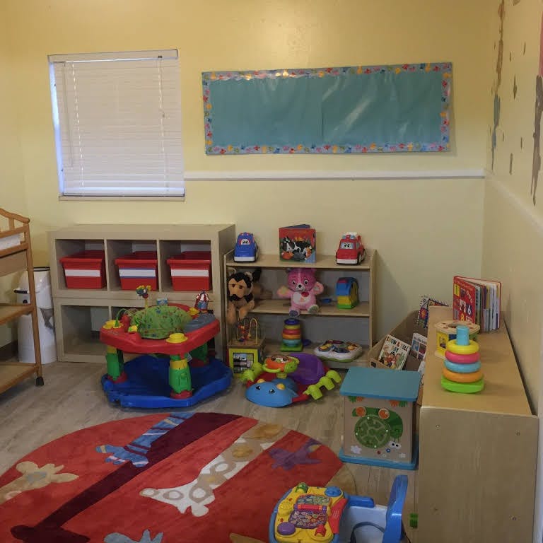 Playroom with toys, shelves, and a colorful rug