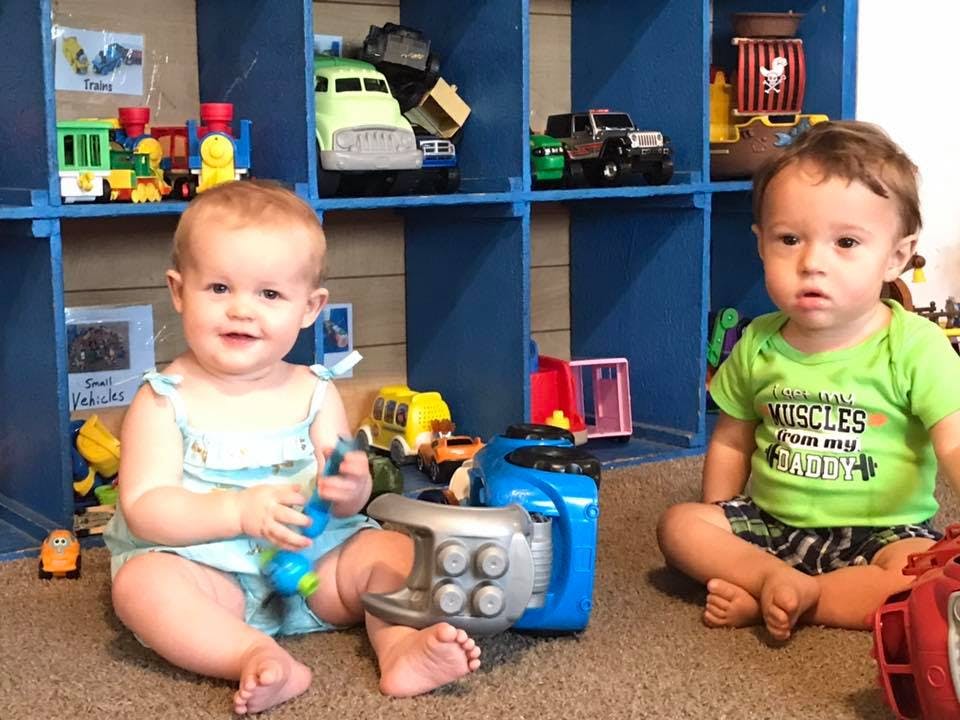 Two children sitting on the floor with toys