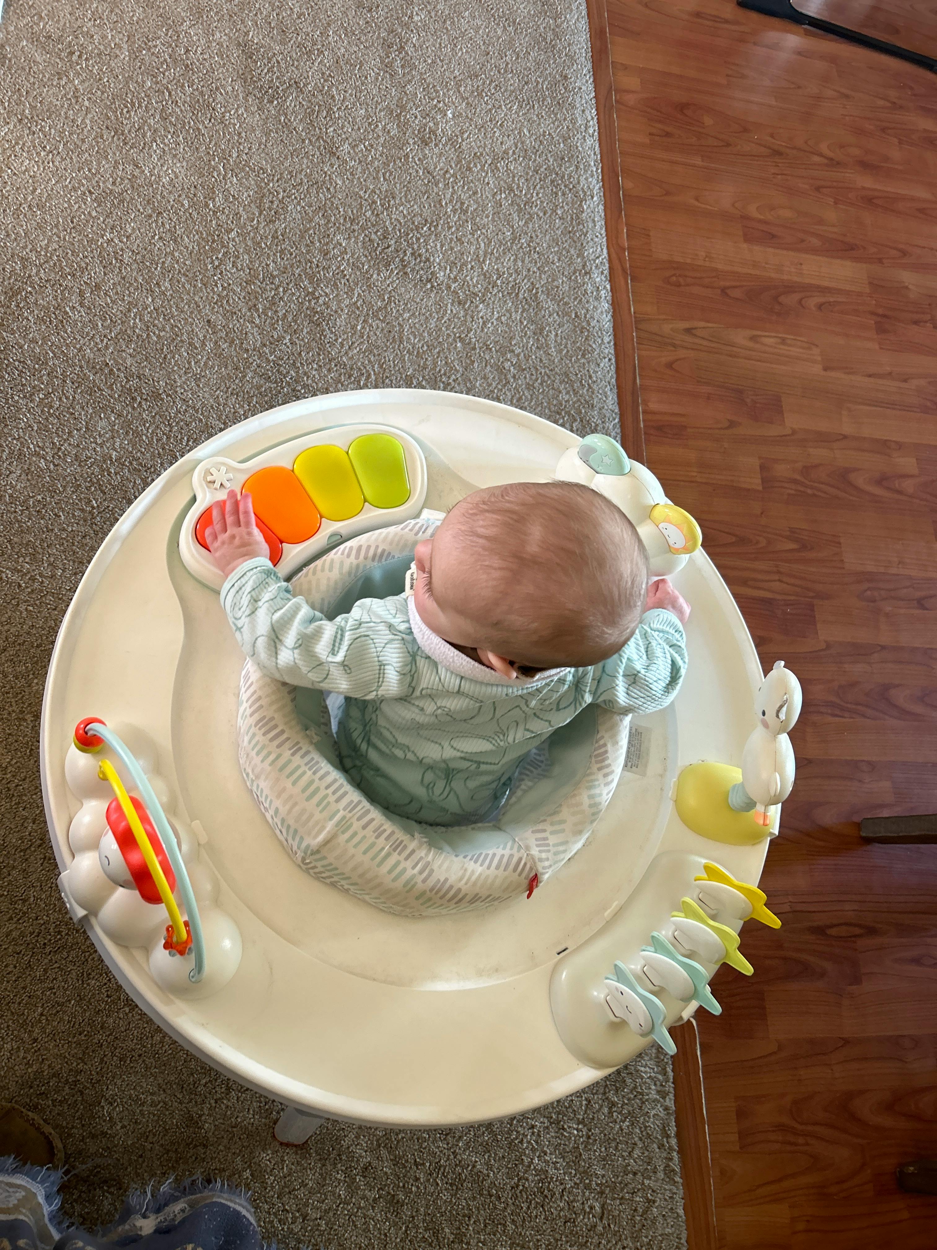 Child in a baby activity center playing with toys