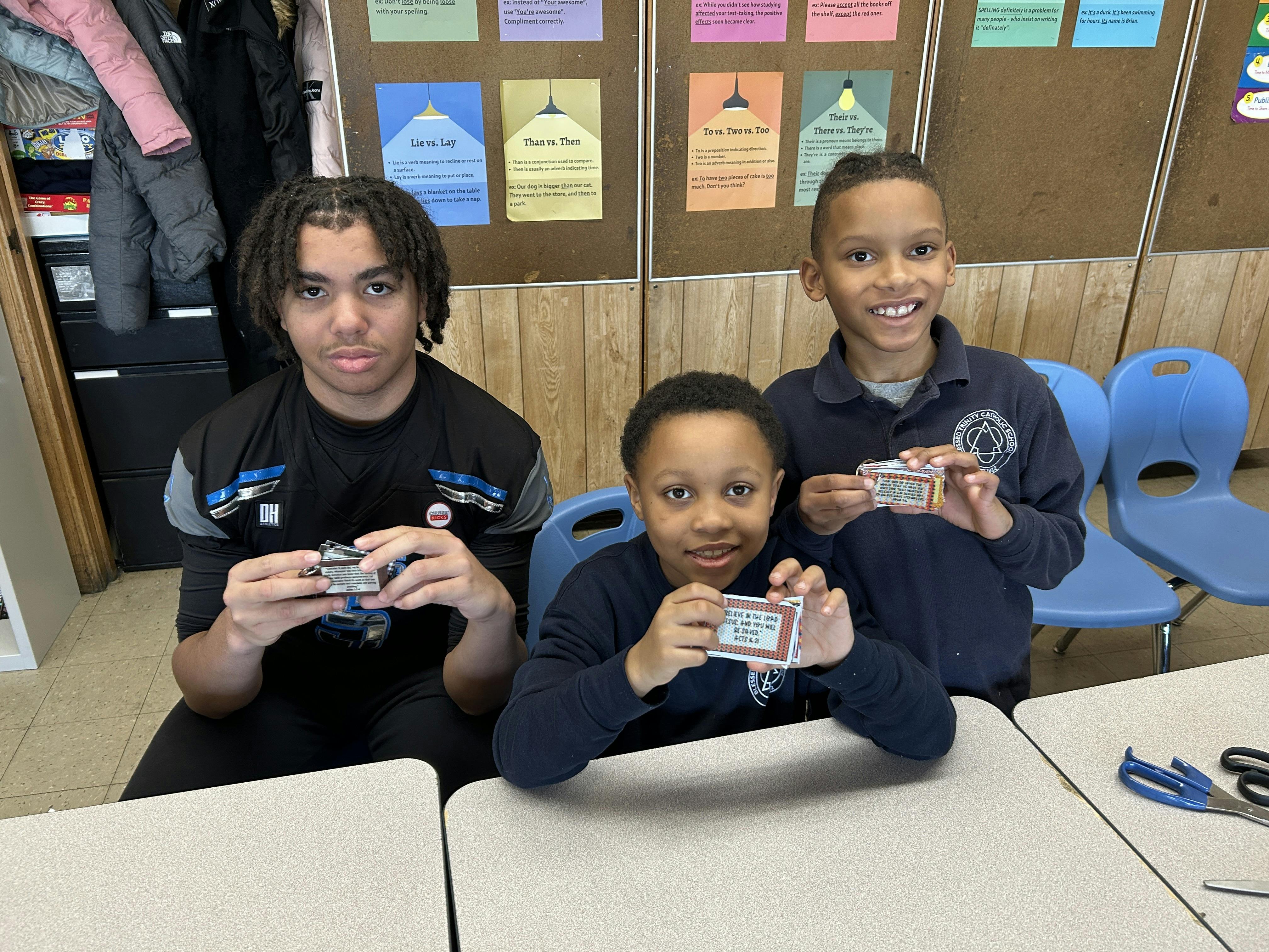 Three people holding small rectangular objects