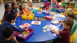 Children at a table playing with learning materials