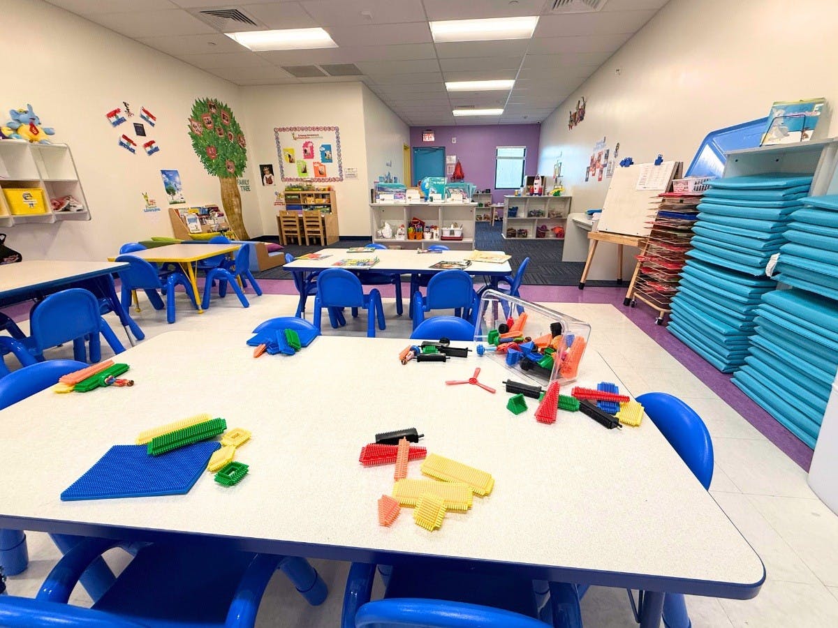 Children's classroom with blue chairs and tables, toys on tables