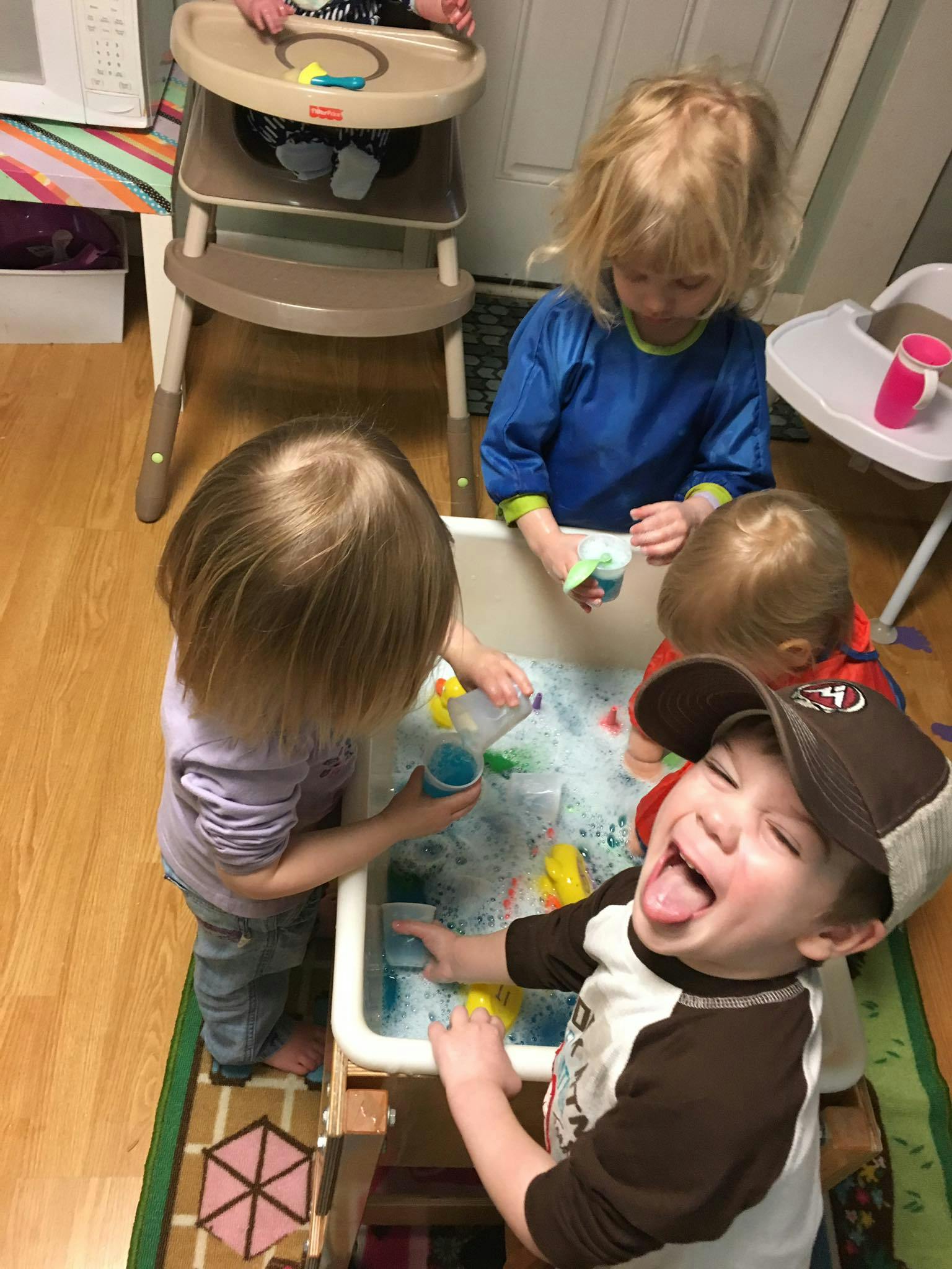 Children playing with water and toys in a sensory bin