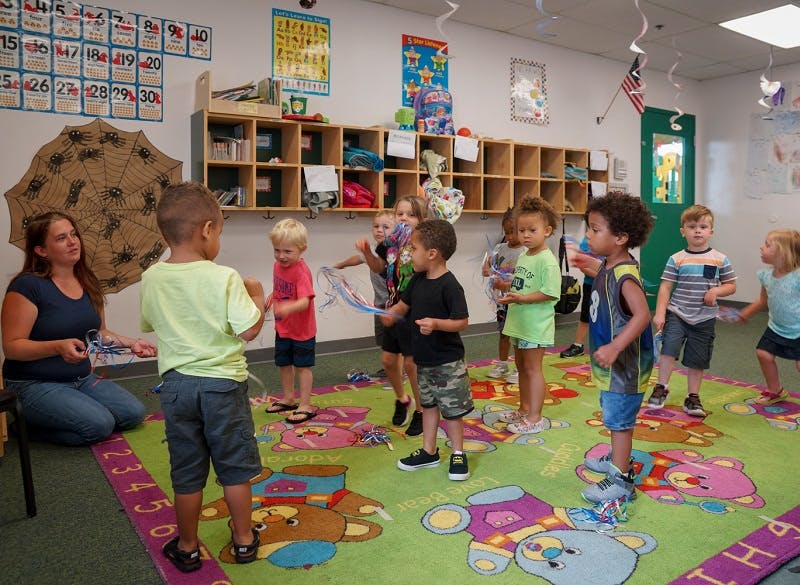 Adult and multiple children in a classroom