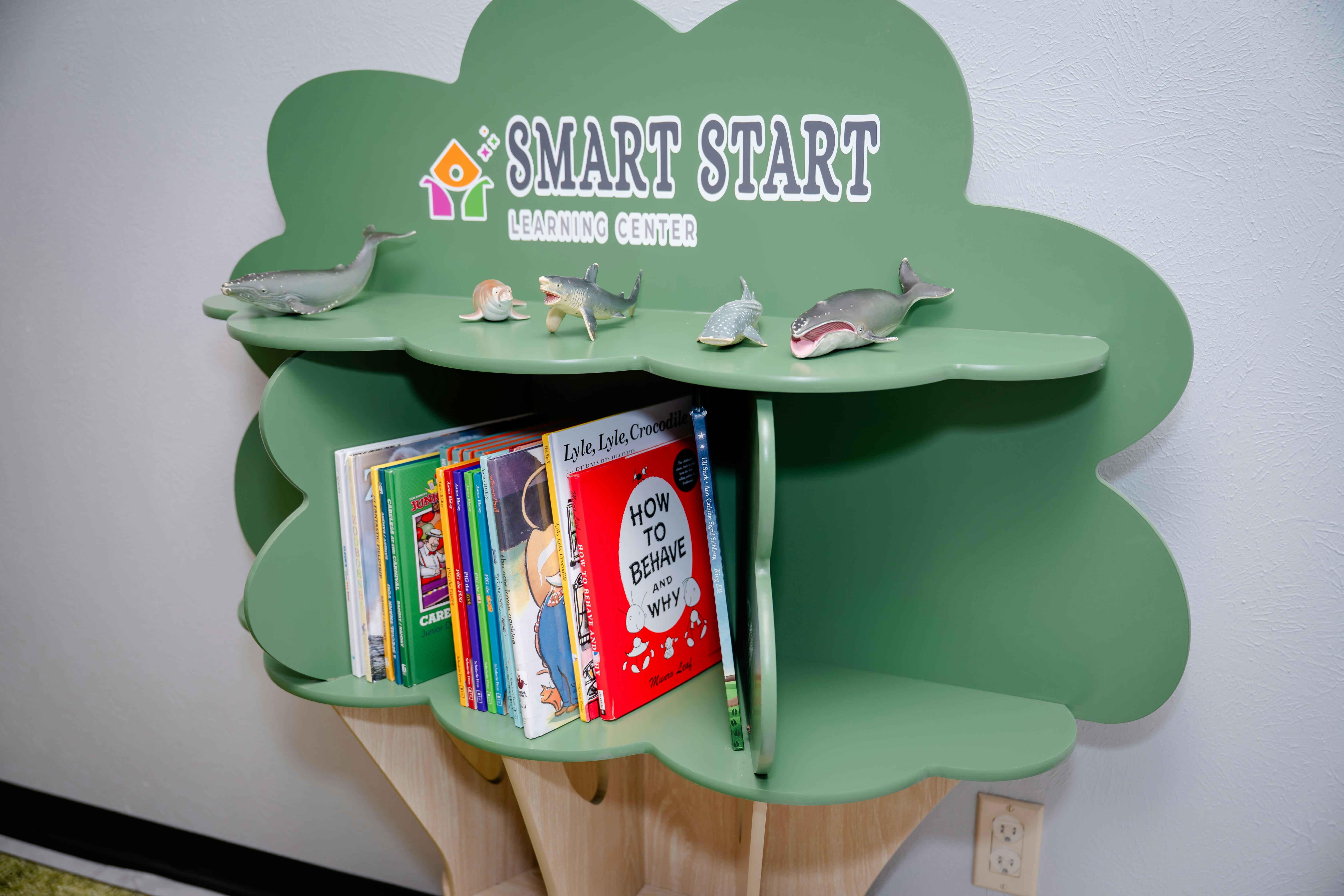 Tree-shaped bookshelf with books and shark figurines, turtle figurines