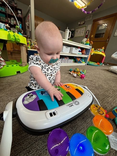 Child playing with a colorful toy piano on the floor