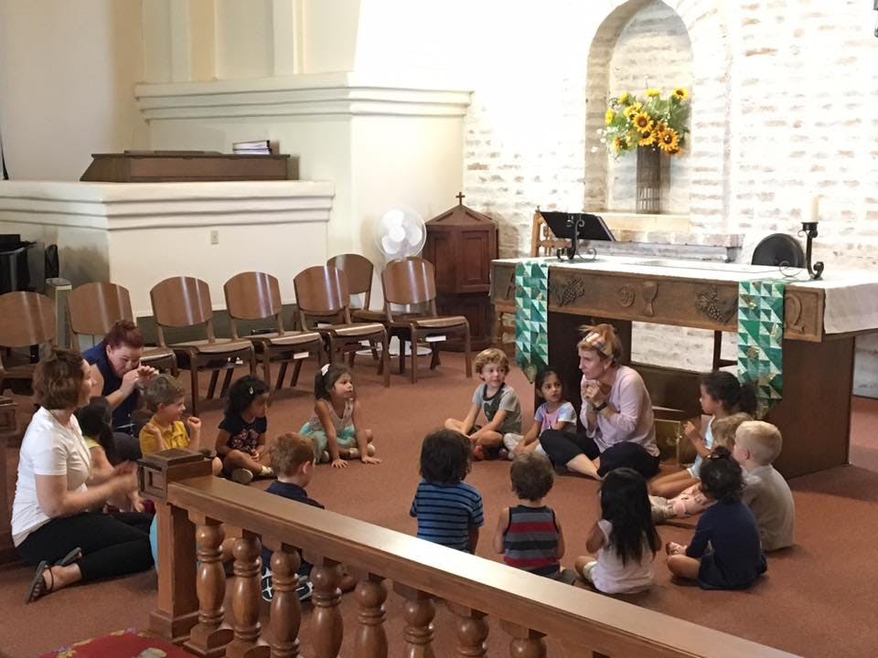 Adults and children sitting on the floor in a circle