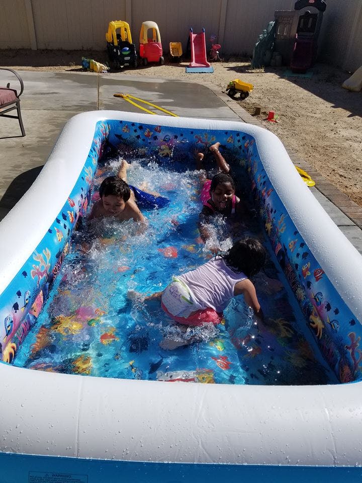 Three children playing in an inflatable pool