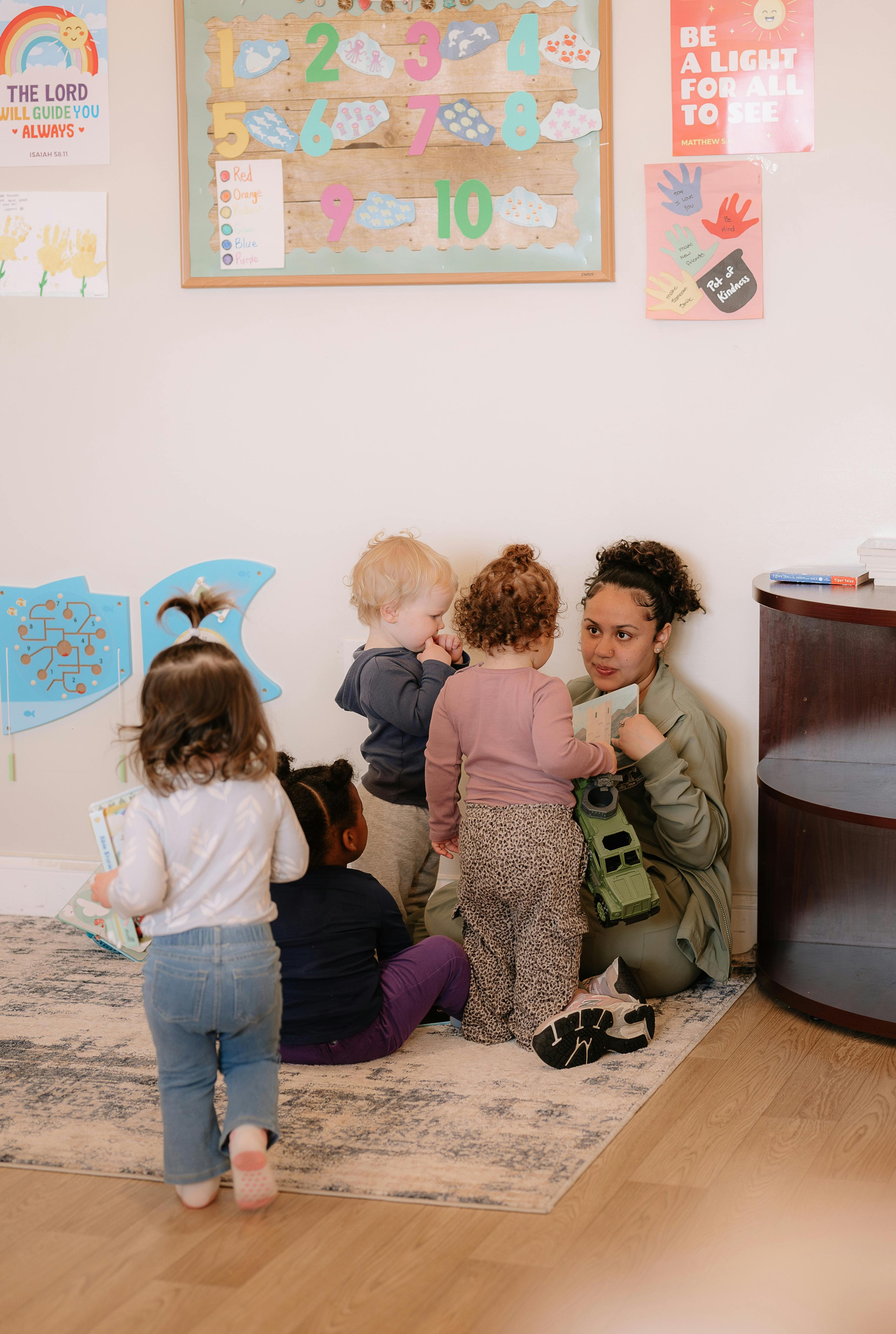 Adult person interacting with three children in a classroom