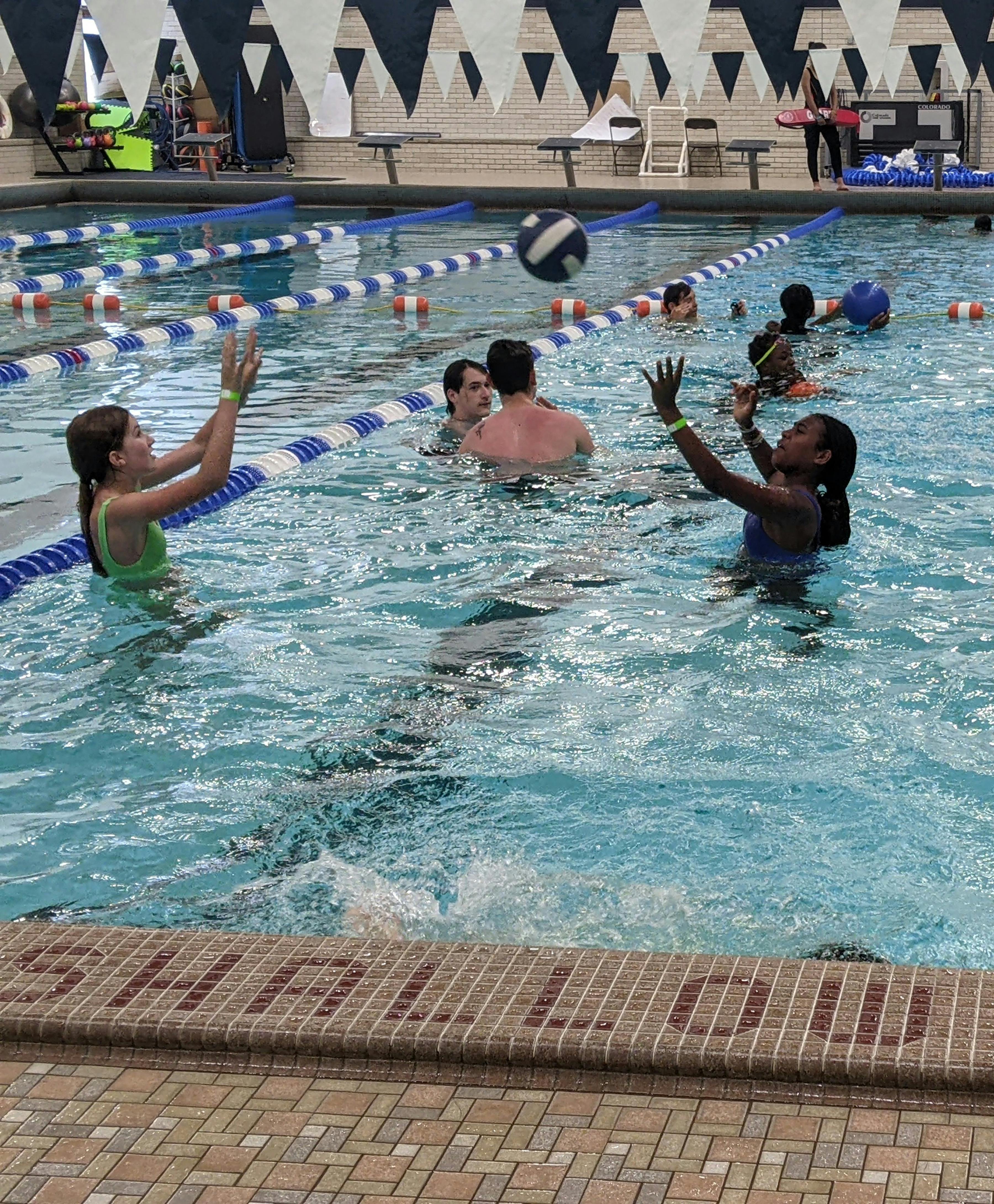 People playing with a ball in a swimming pool