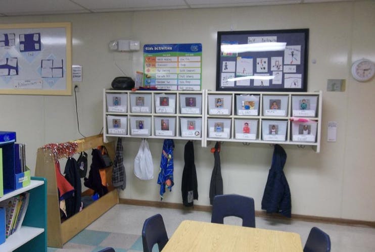 Classroom wall with cubbies for children's belongings and artwork displays of self-portraits