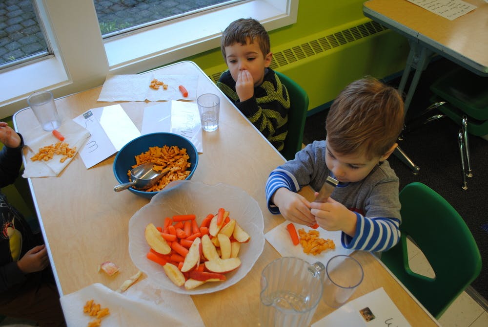 Two children eating snacks at a table
