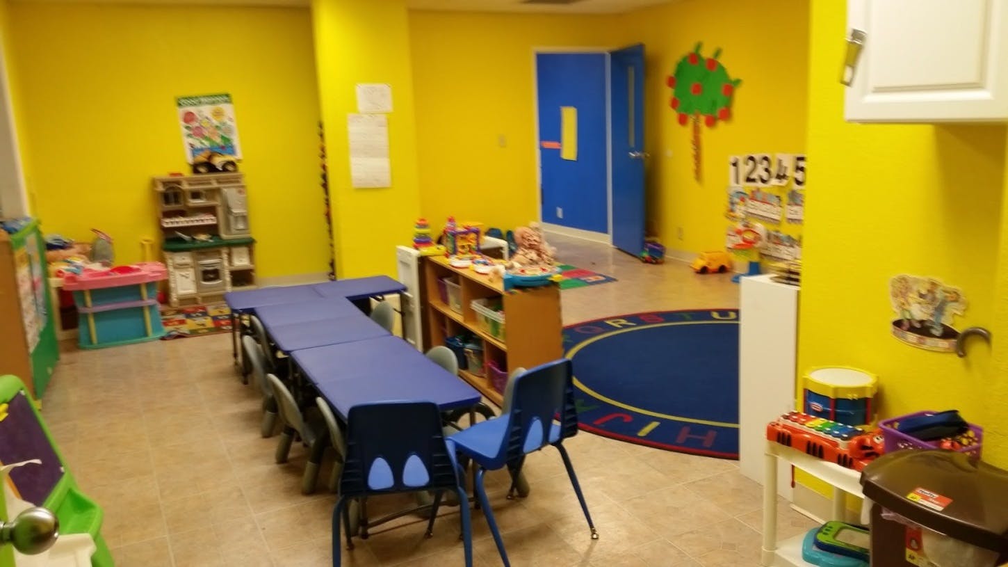 Classroom with yellow walls, blue tables, and chairs