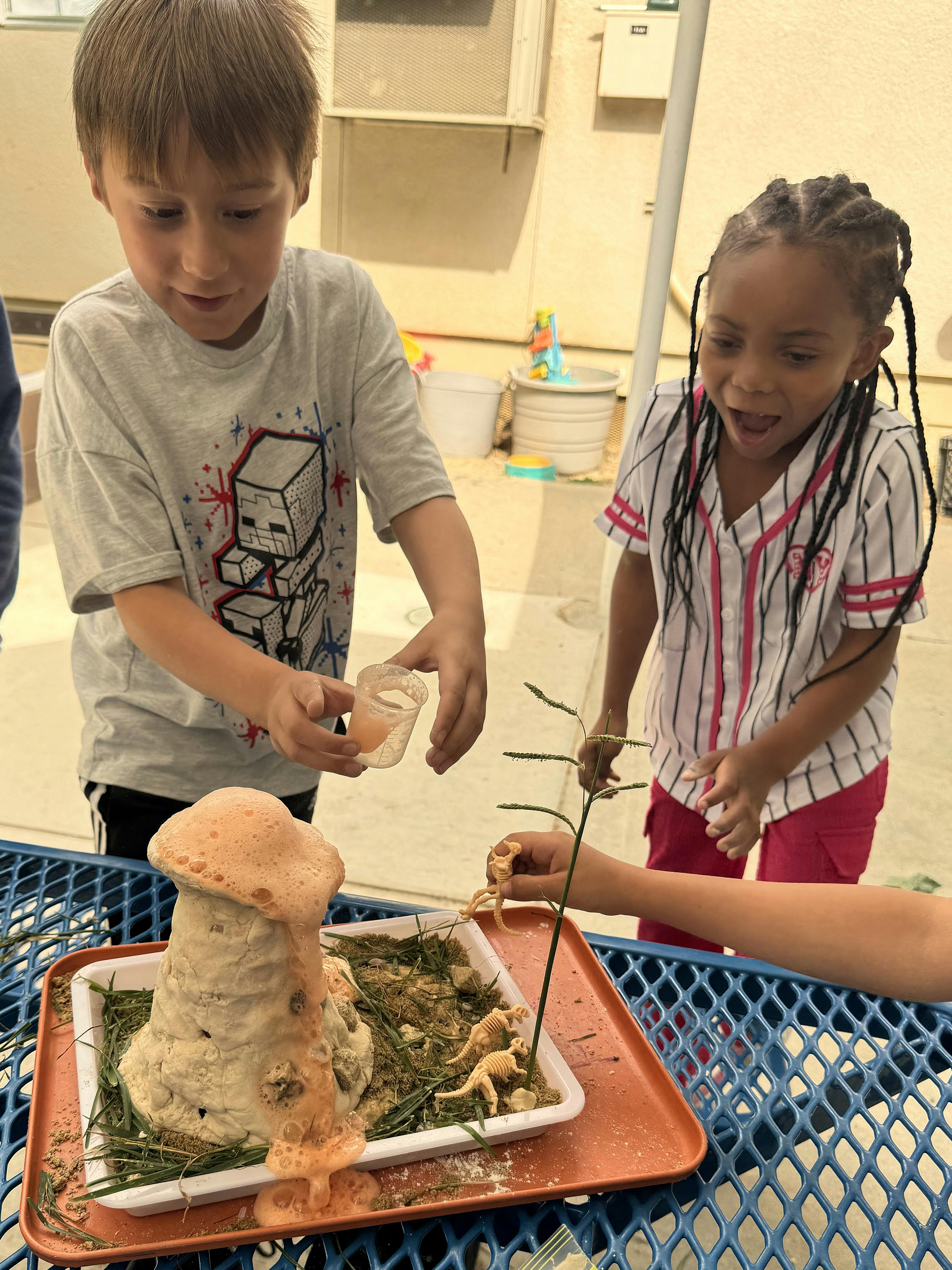 Children conducting a science experiment with a model volcano