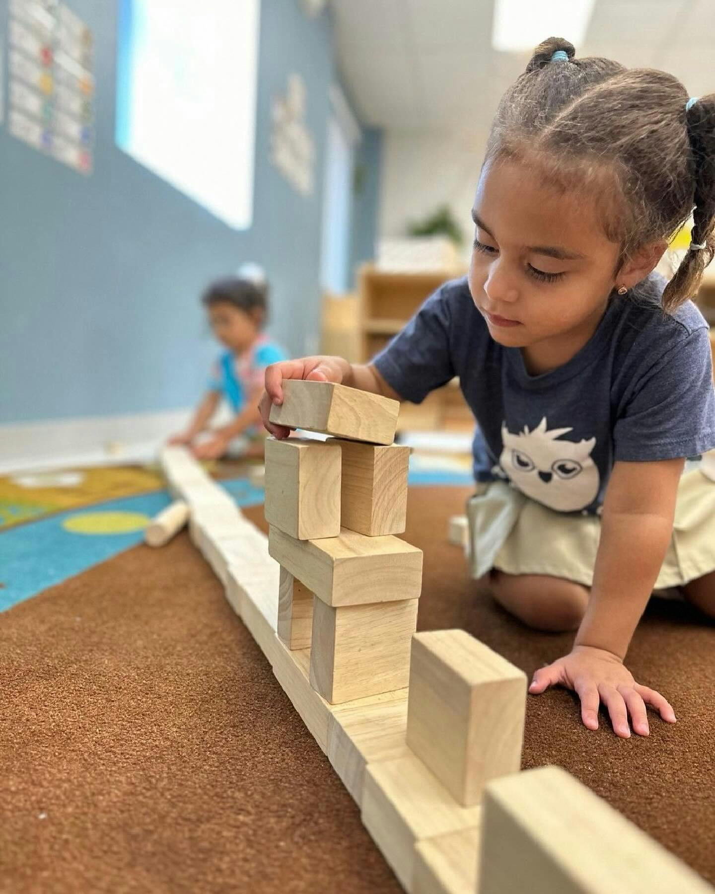 Child building with wooden blocks on the floor