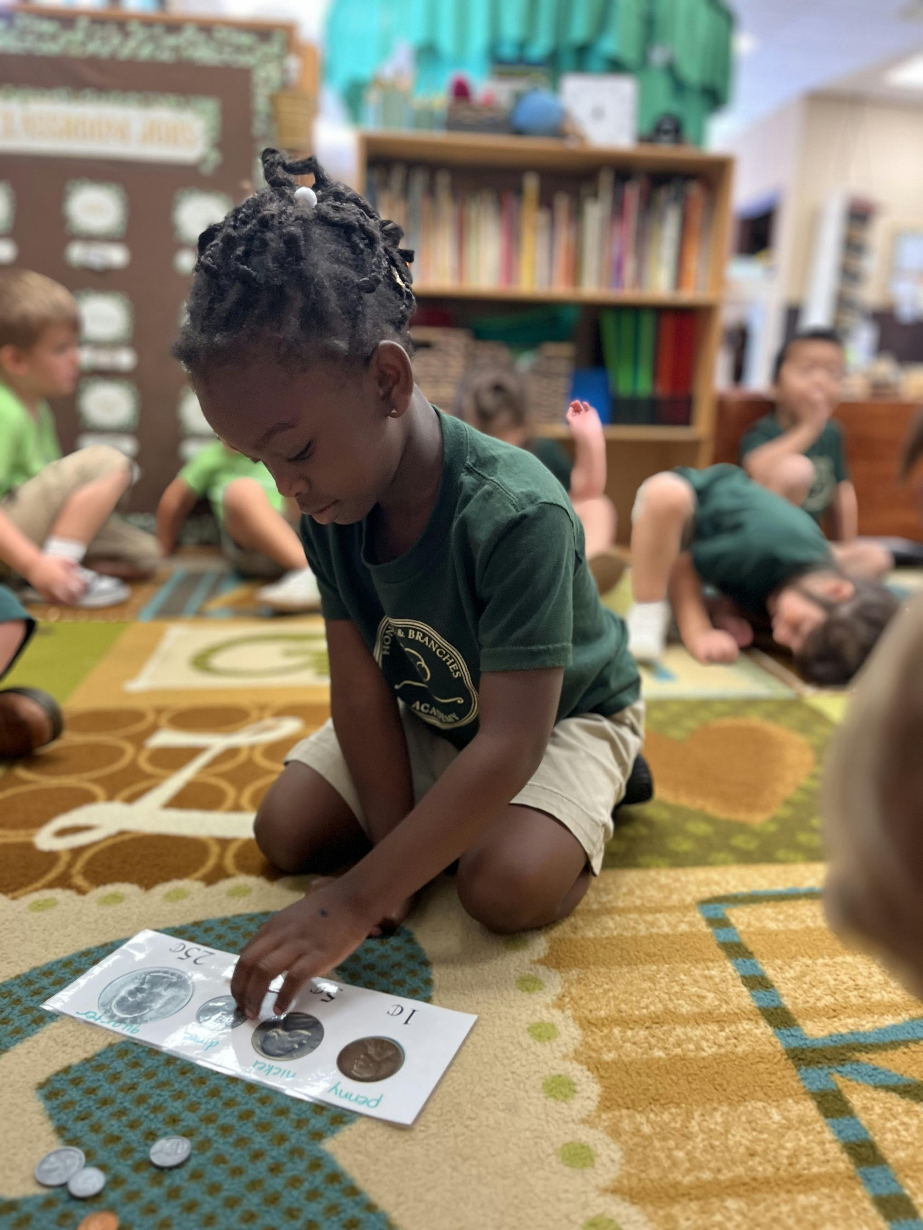 Child kneeling on a rug, placing coins into a coin holder