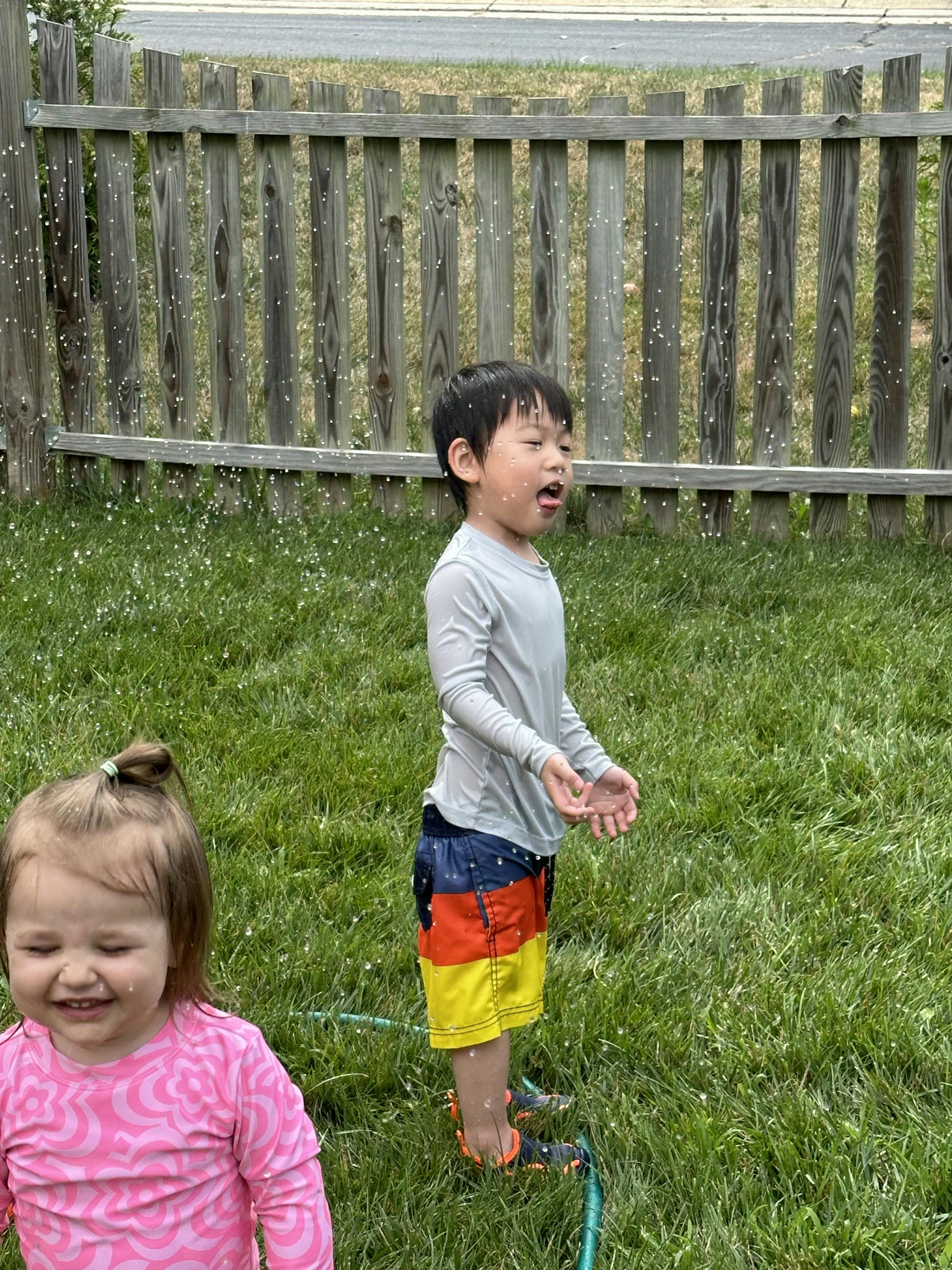 Child playing in sprinkler with water drops on face