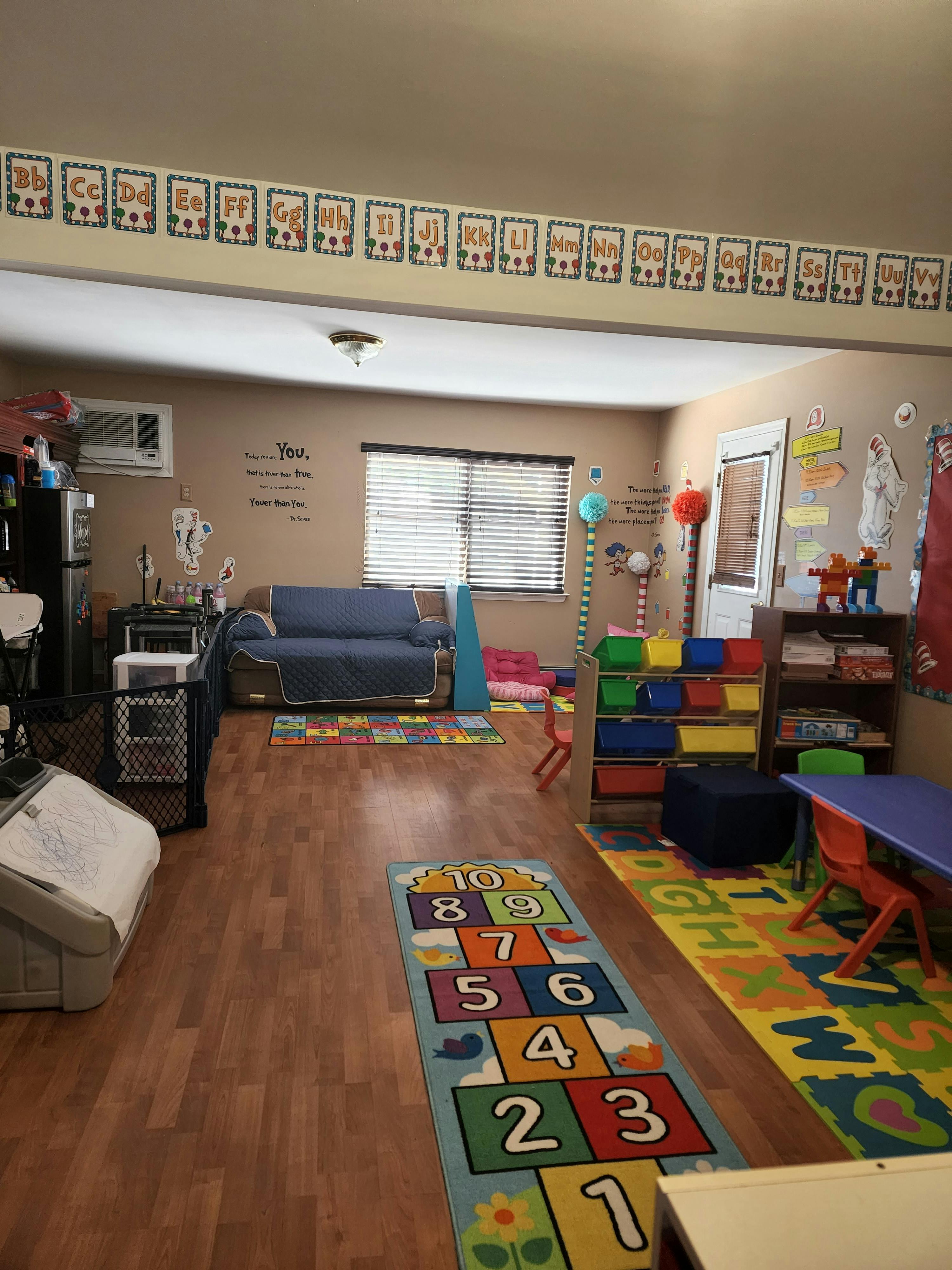 Playroom with colorful rugs, toys, and a blue sofa