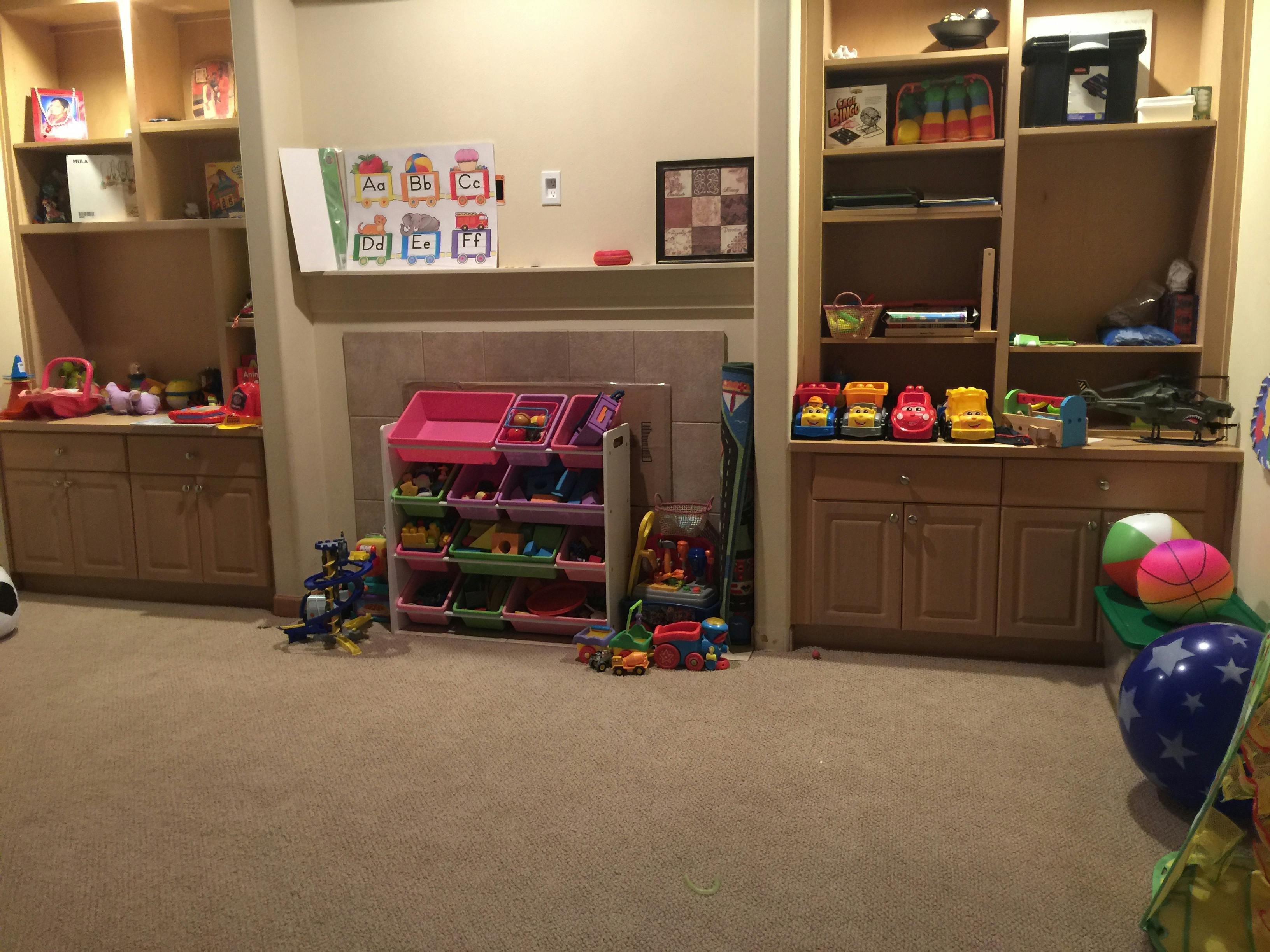 Playroom with toy storage shelves and built-in wooden cabinets