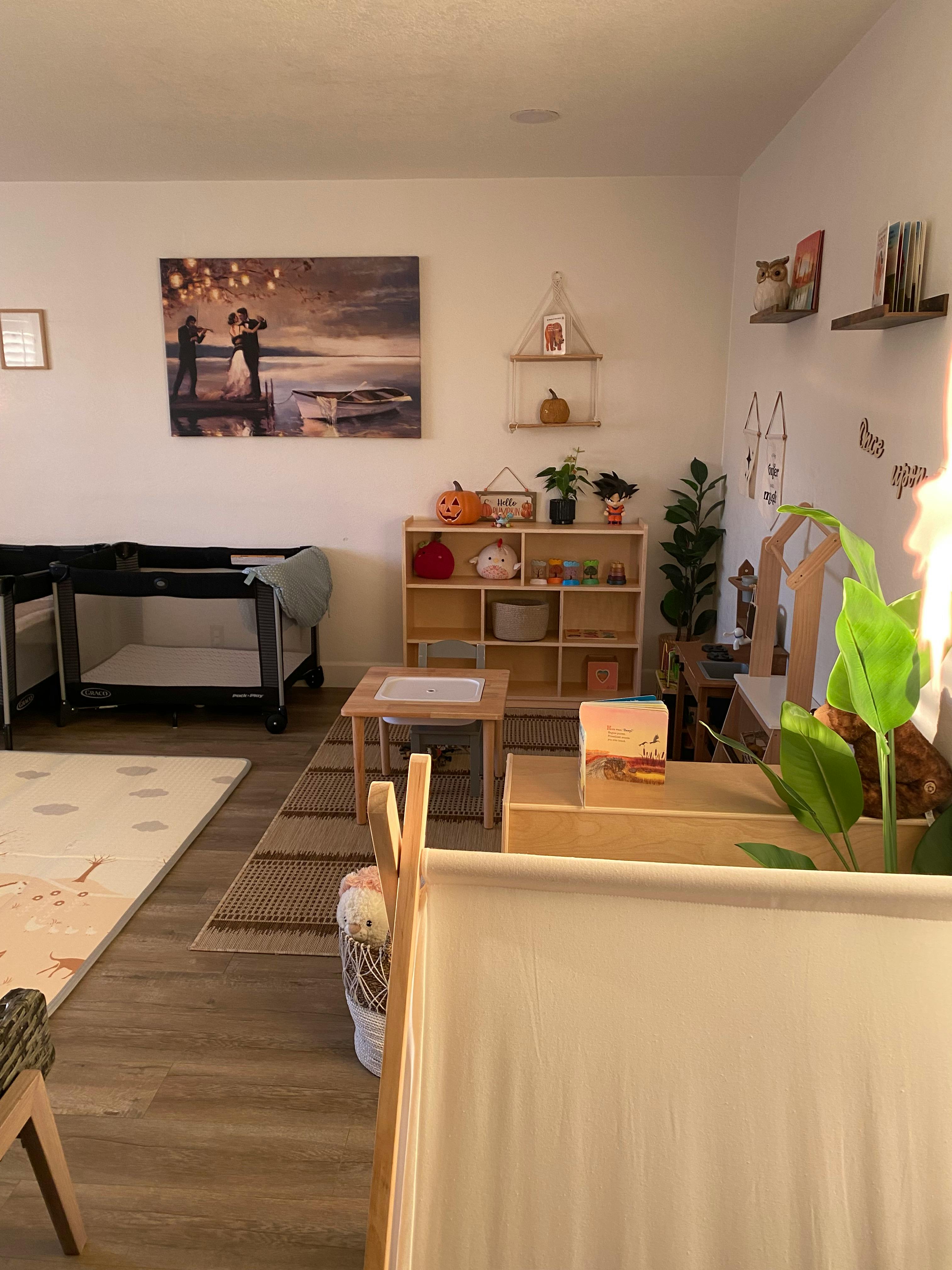 Room with a painting, shelves, and baby cribs
