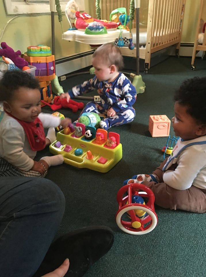 Three children playing with toys on the floor