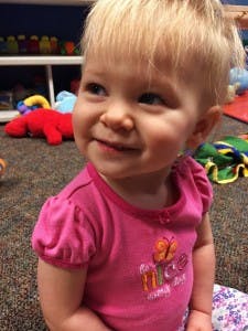 Child in pink shirt smiling