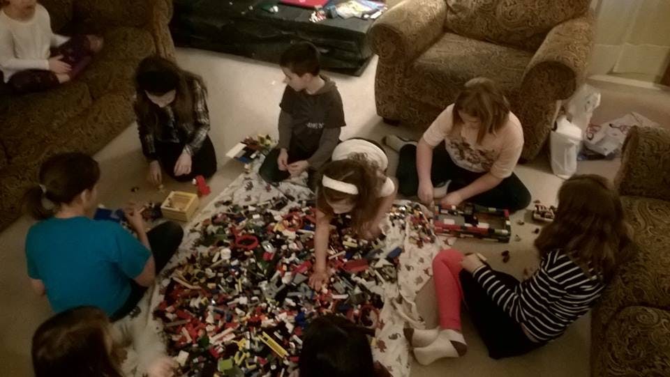 Group of children and teens playing with building blocks on the floor