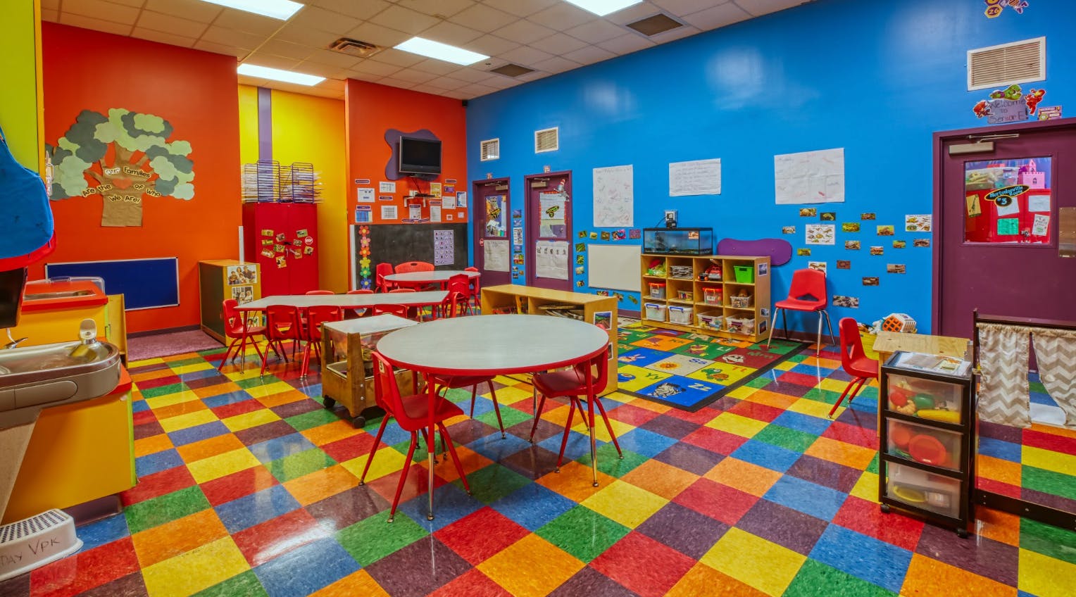 Colorful classroom with child-sized tables and chairs, and a checkered floor