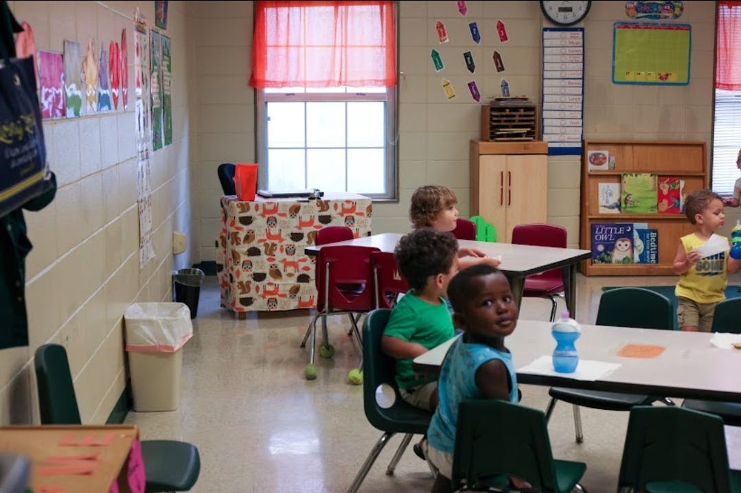 Children sitting at tables in a classroom