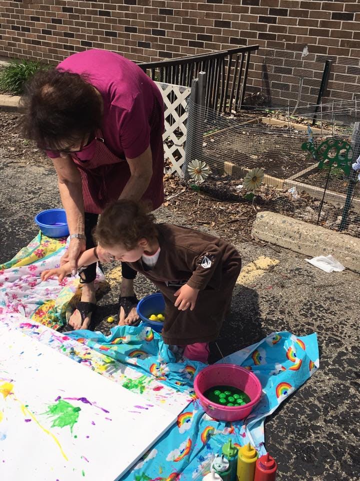Person and child painting outdoors