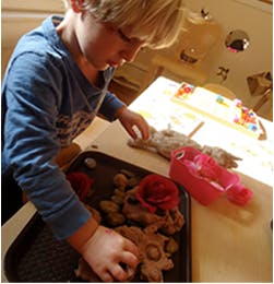 Child playing with objects on a tray
