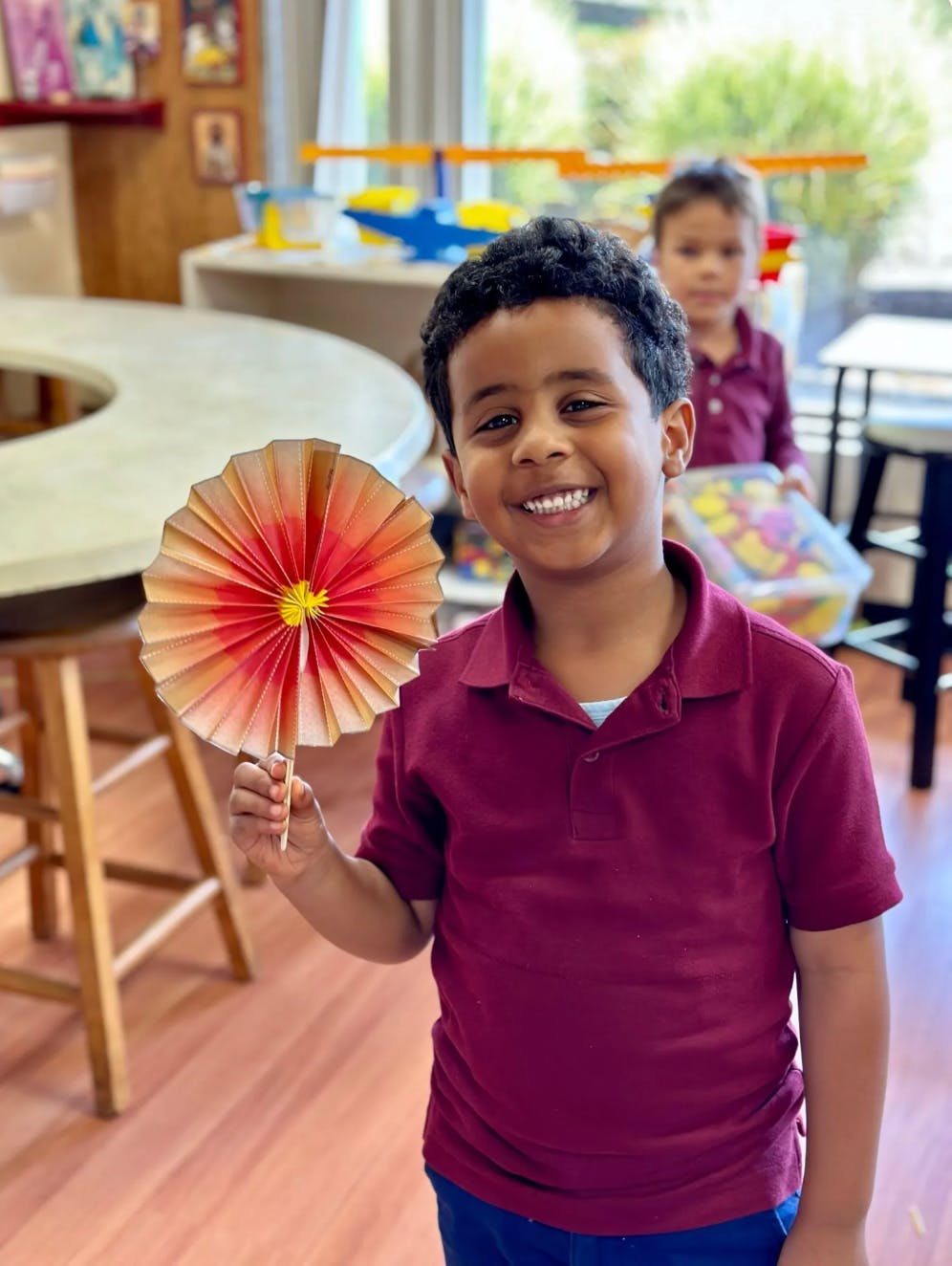Child holding a paper fan