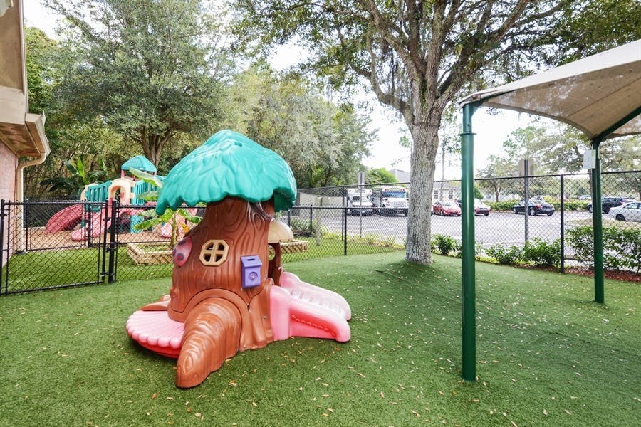 Playground with a tree-shaped play structure and artificial turf