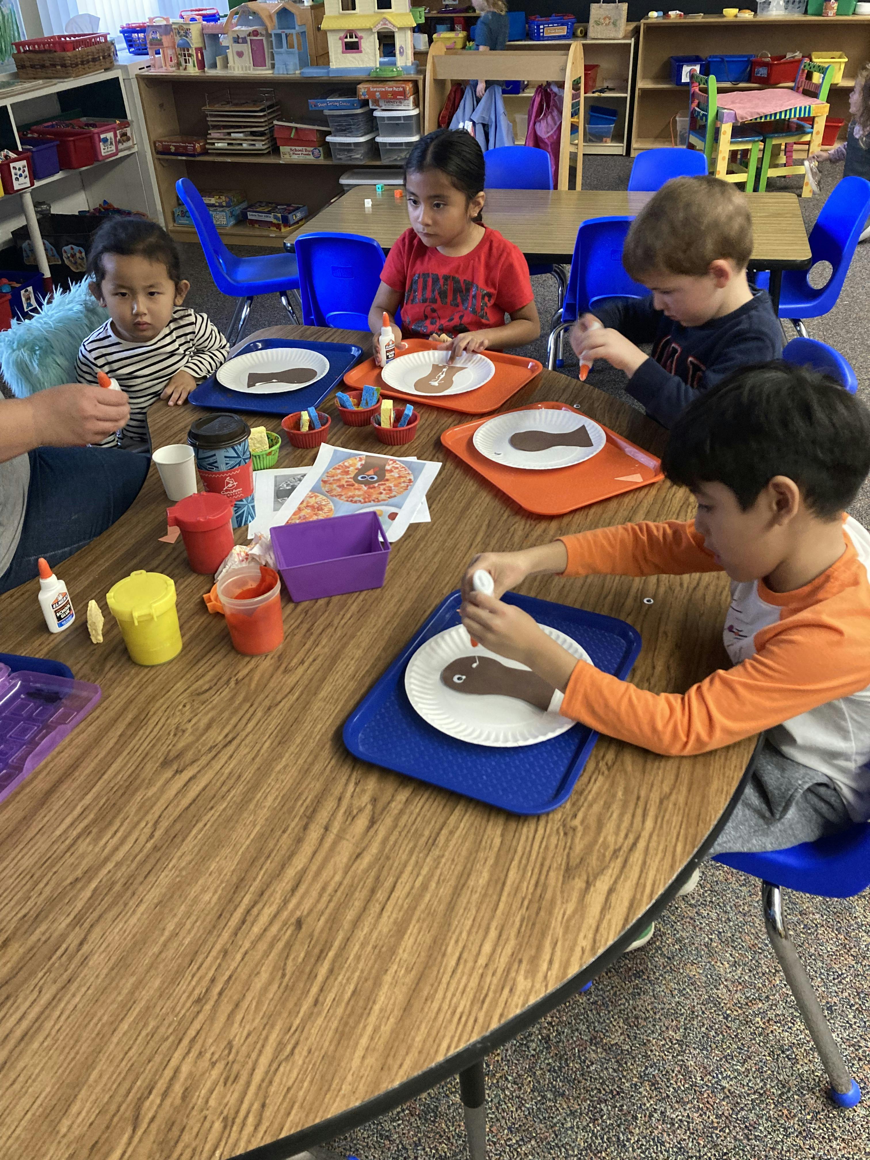 Children doing an art project with paper plates and glue