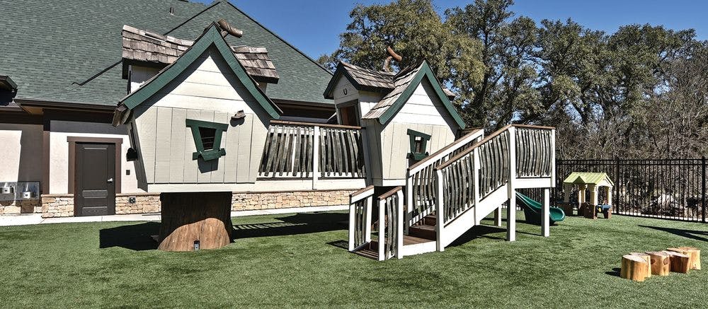 Play structure with small houses and stairs on artificial grass