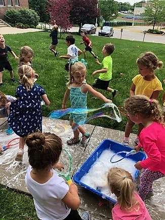 Children playing with bubbles outdoors