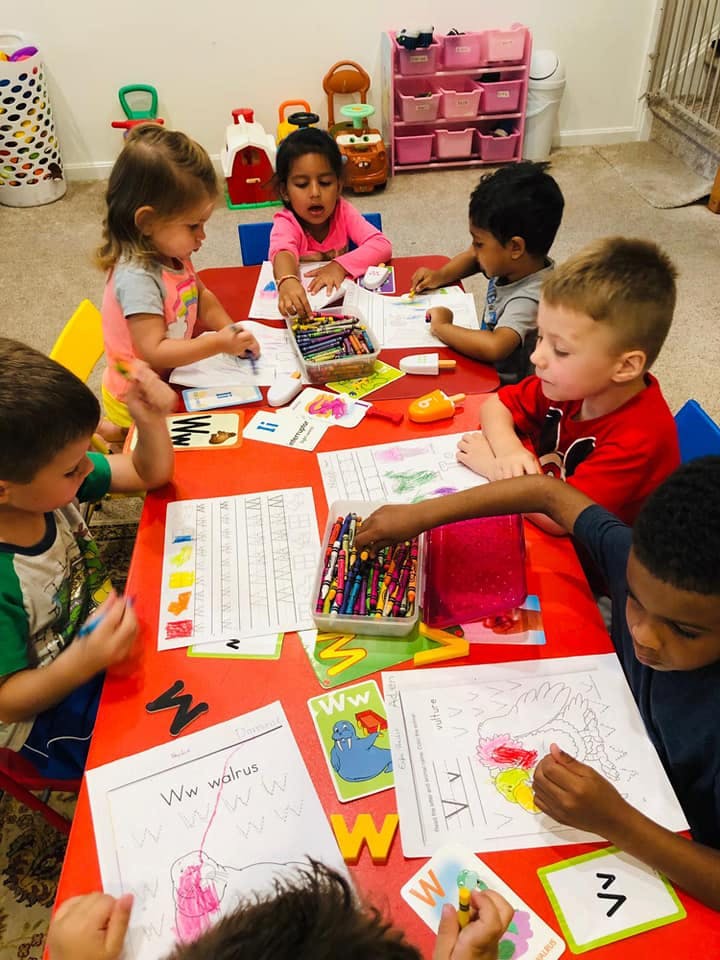 Children sitting at a table coloring and drawing