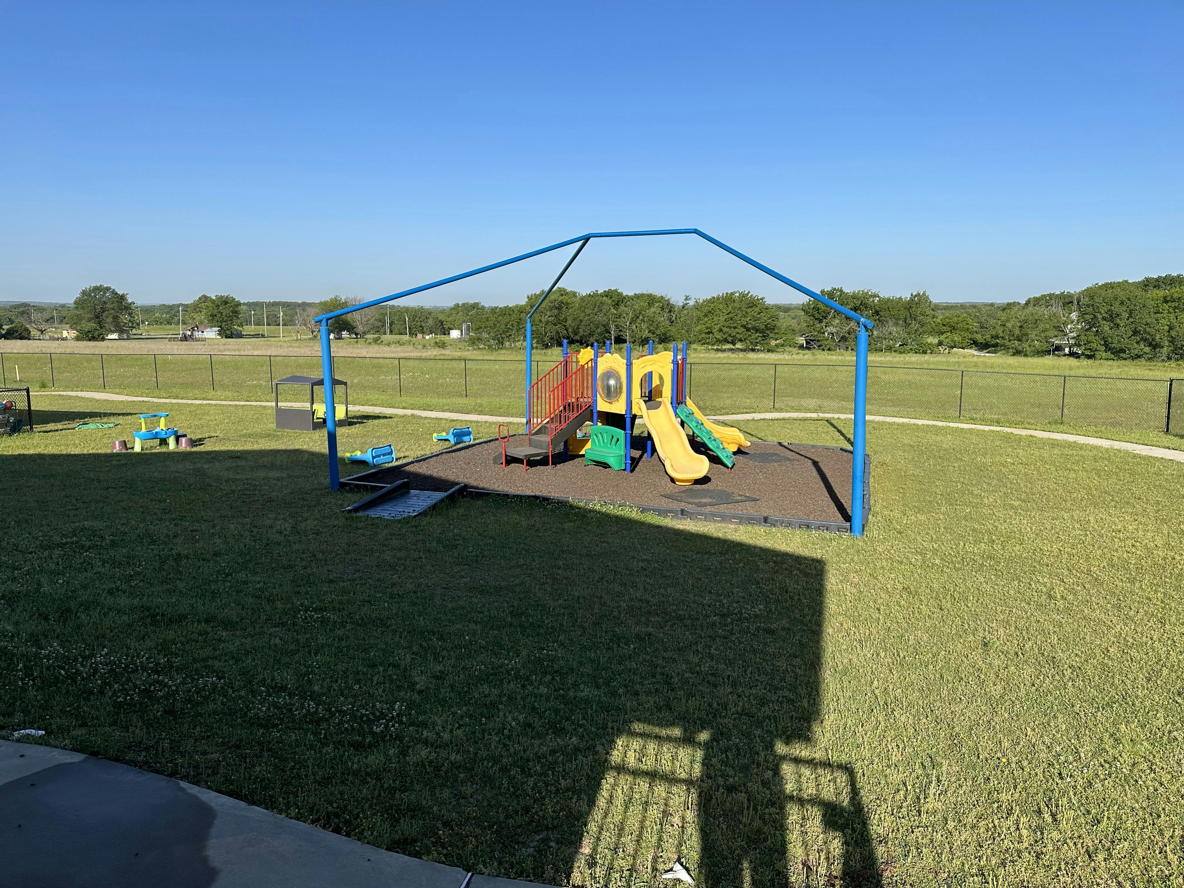 Playground with slides and climbing structures on a grassy field